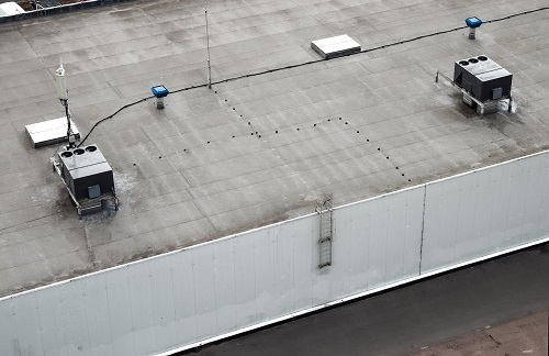 The external units of the commercial air conditioning and ventilation systems are installed on the roof of an industrial building.
